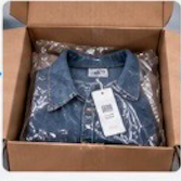 Opened box showing a denim shirt in its original bag